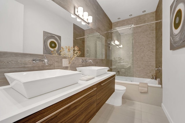 full bath with enclosed tub / shower combo, tile patterned flooring, a sink, and toilet