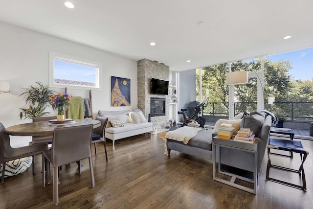 living room with a wall of windows, a fireplace, wood finished floors, and recessed lighting