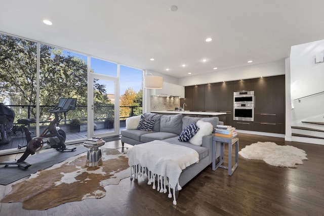 living area with stairway, floor to ceiling windows, dark wood finished floors, and recessed lighting