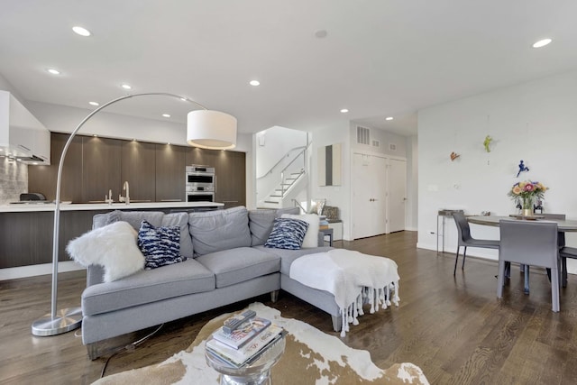 living area with recessed lighting, visible vents, stairway, and wood finished floors