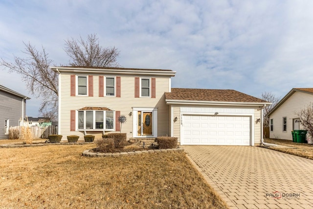 view of front of house with decorative driveway, an attached garage, and a front yard