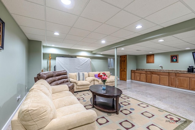 living room with baseboards, a paneled ceiling, and recessed lighting