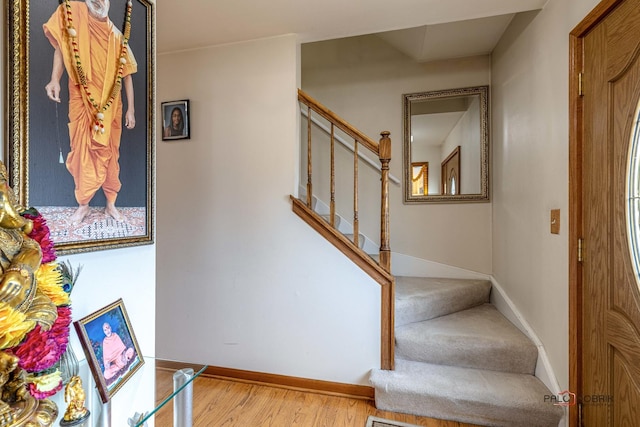 stairway featuring baseboards and wood finished floors