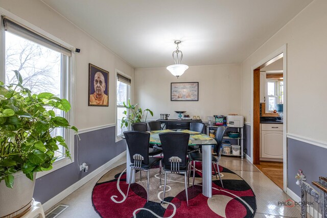 dining area with a wealth of natural light, visible vents, and baseboards