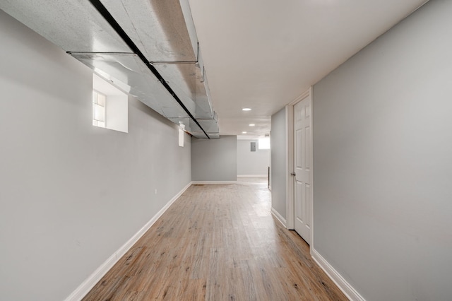 basement featuring baseboards, wood finished floors, and recessed lighting