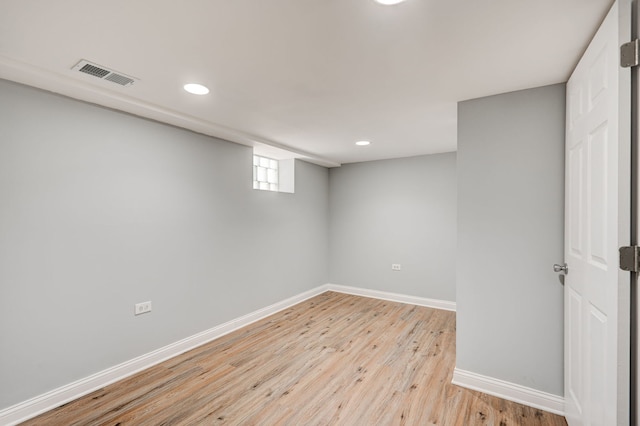 below grade area with light wood finished floors, recessed lighting, visible vents, and baseboards