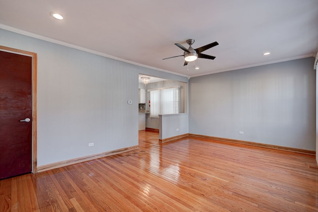 empty room with ornamental molding, ceiling fan, light wood-style flooring, and baseboards