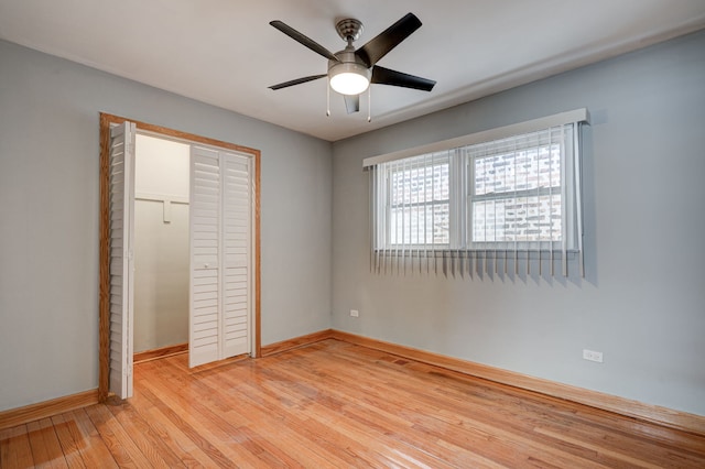 unfurnished bedroom with light wood-type flooring, ceiling fan, baseboards, and a closet