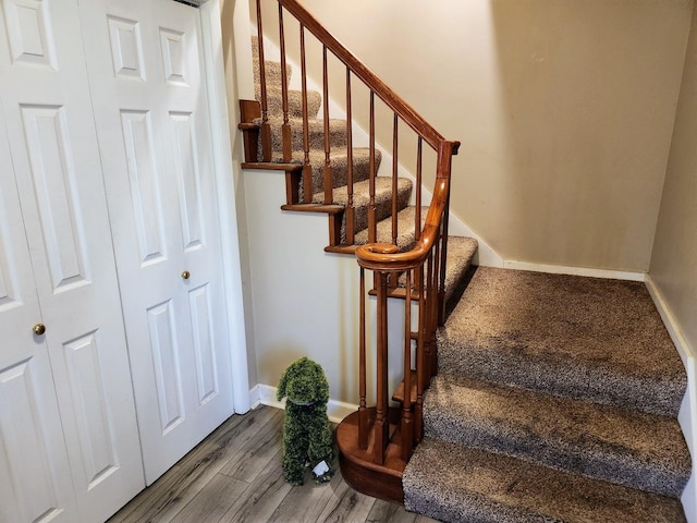 stairway featuring baseboards and wood finished floors