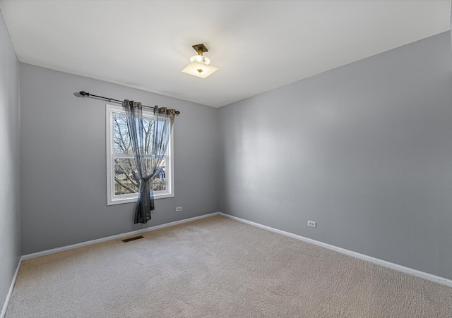 carpeted empty room featuring visible vents and baseboards