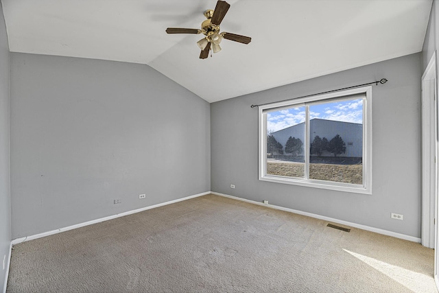 spare room with carpet flooring, a ceiling fan, visible vents, vaulted ceiling, and baseboards