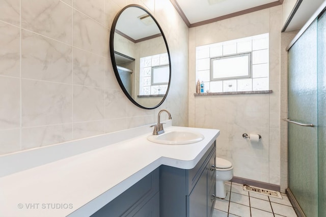 full bath with crown molding, tile walls, a stall shower, vanity, and tile patterned flooring