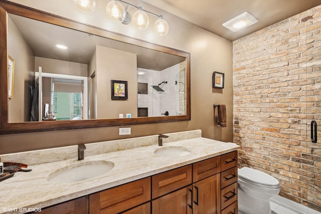 full bathroom featuring toilet, double vanity, a tile shower, and a sink