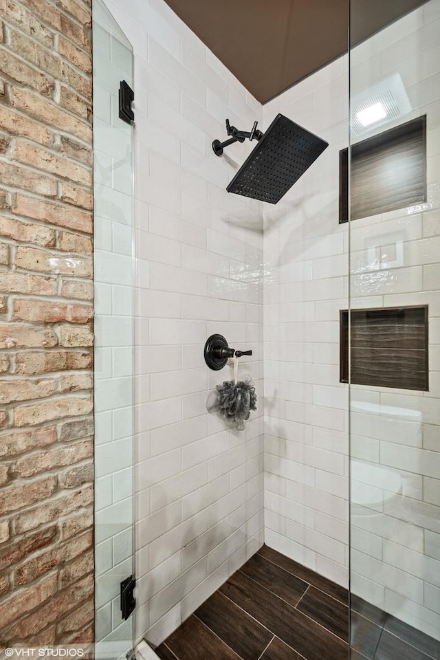 full bath featuring a stall shower and wood finished floors