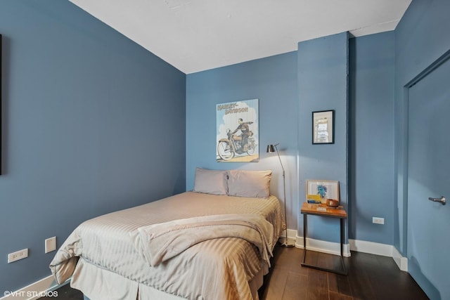 bedroom featuring wood finished floors and baseboards