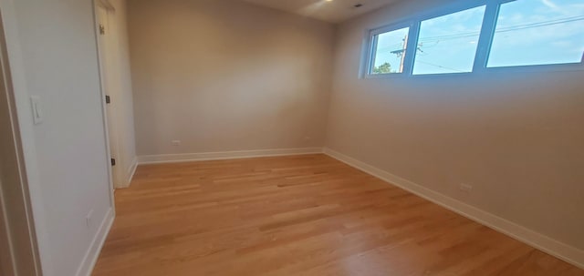 empty room with light wood finished floors and baseboards