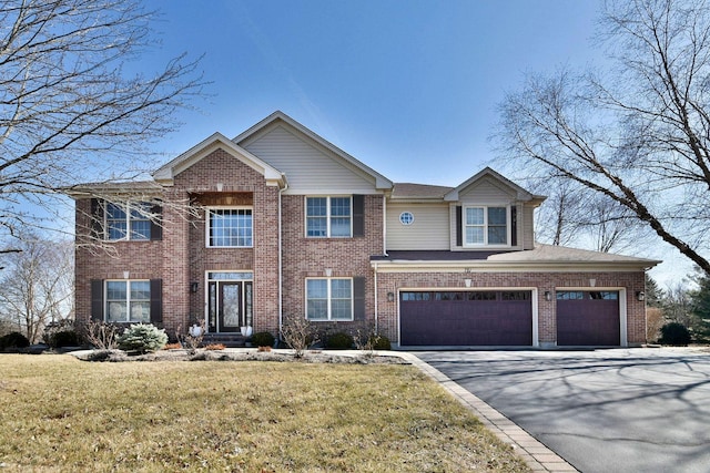 view of front of house featuring aphalt driveway, brick siding, and a front yard