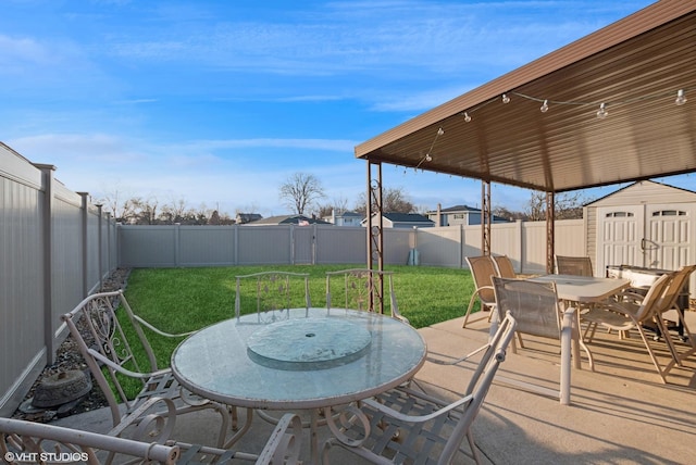 view of patio with outdoor dining area, a fenced backyard, an outdoor structure, and a storage shed