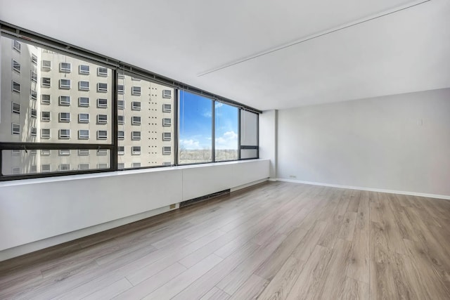 empty room with baseboards and wood finished floors