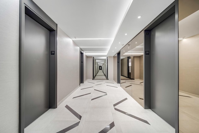 hall with recessed lighting, baseboards, and elevator