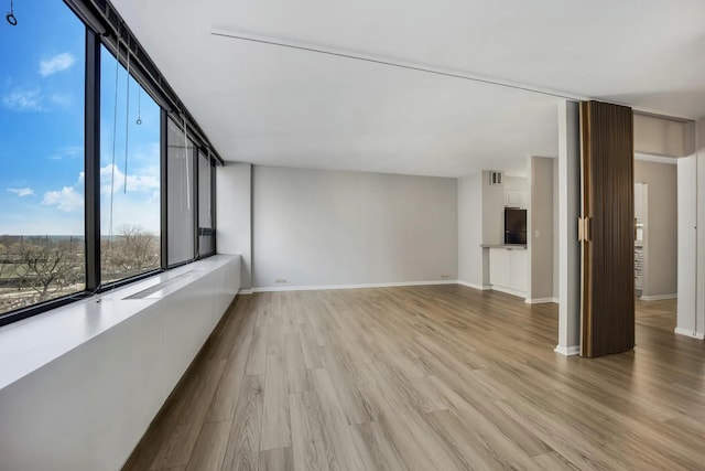 empty room with visible vents, baseboards, and light wood finished floors