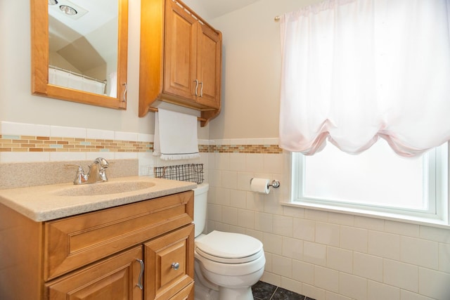 4128 N Plainfield Ave, Chicago, IL 60634 - bathroom with tile walls, toilet, vanity, and wainscoting