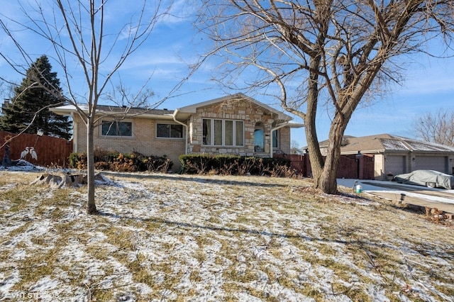 view of front of property with stone siding, brick siding, and fence