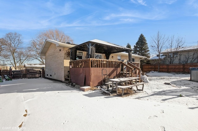 rear view of property with a gazebo, brick siding, fence, and a gate