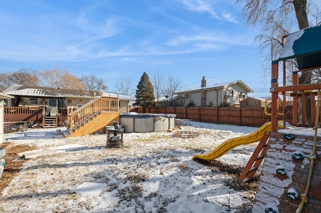 yard layered in snow with a fenced in pool, fence, and a wooden deck