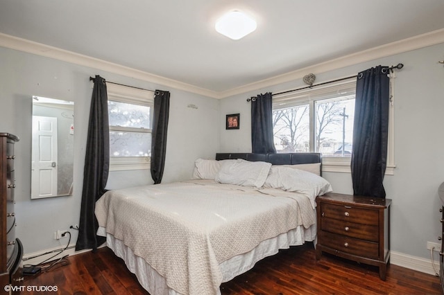 bedroom with a baseboard radiator, multiple windows, and wood finished floors