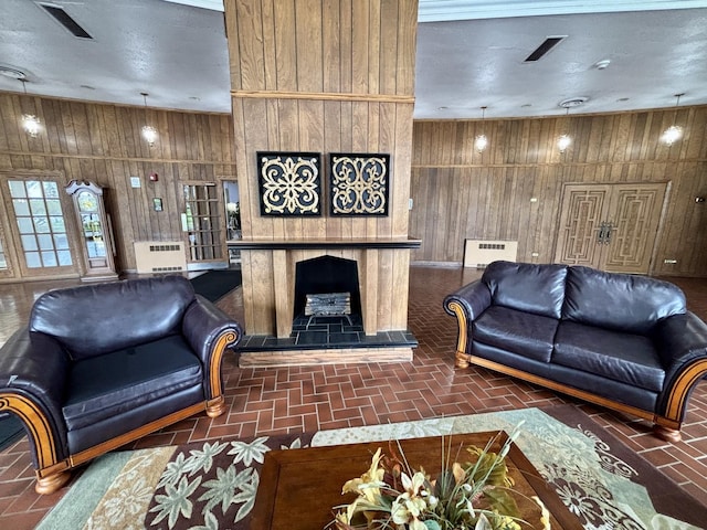 living area with visible vents, wood walls, brick floor, and a fireplace