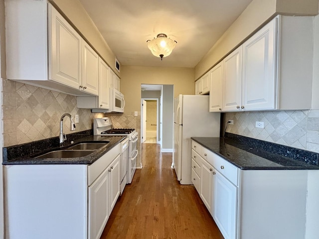 kitchen featuring white appliances, white cabinetry, a sink, and wood finished floors