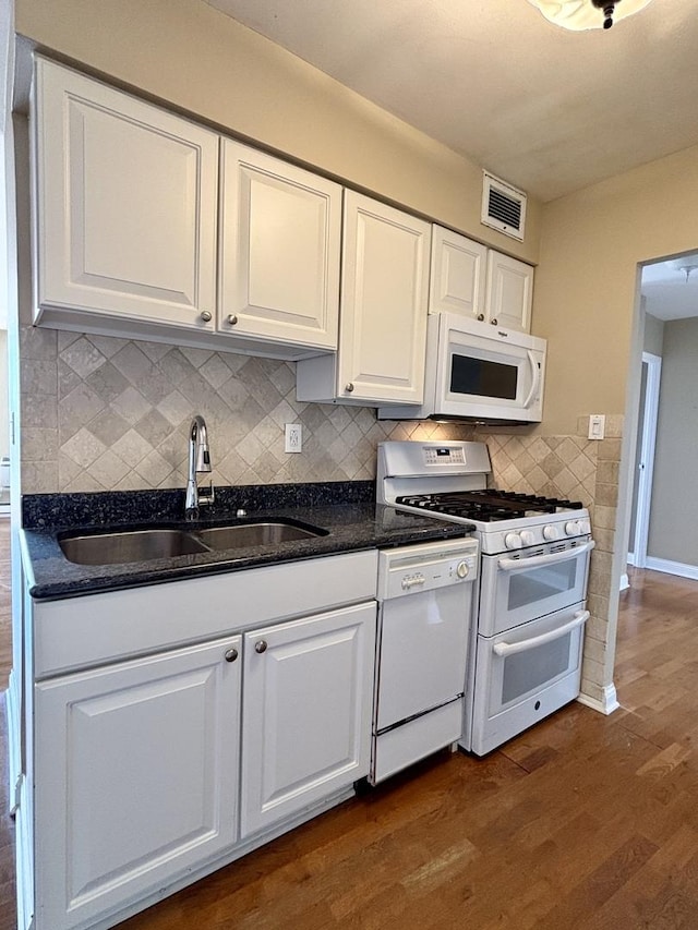 kitchen featuring a sink, white appliances, white cabinetry, dark wood-type flooring, and visible vents