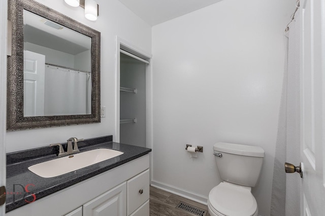 full bathroom featuring baseboards, visible vents, toilet, wood finished floors, and vanity