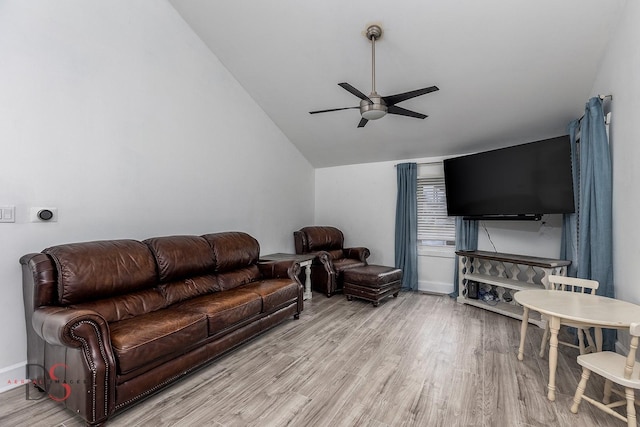 living room featuring a ceiling fan, vaulted ceiling, baseboards, and wood finished floors