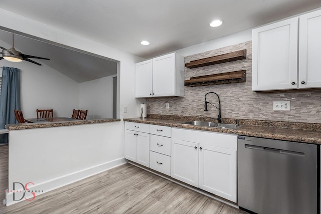 kitchen with a sink, dark countertops, light wood-style floors, and dishwasher