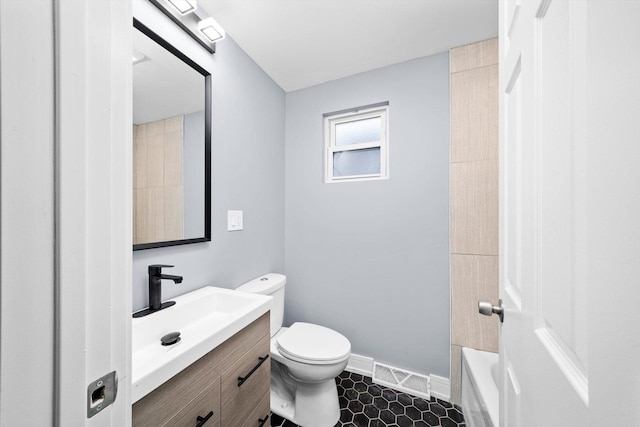 bathroom with a washtub, visible vents, toilet, vanity, and baseboards