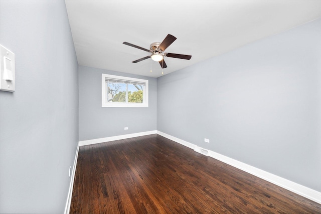 empty room with dark wood-type flooring, visible vents, baseboards, and a ceiling fan