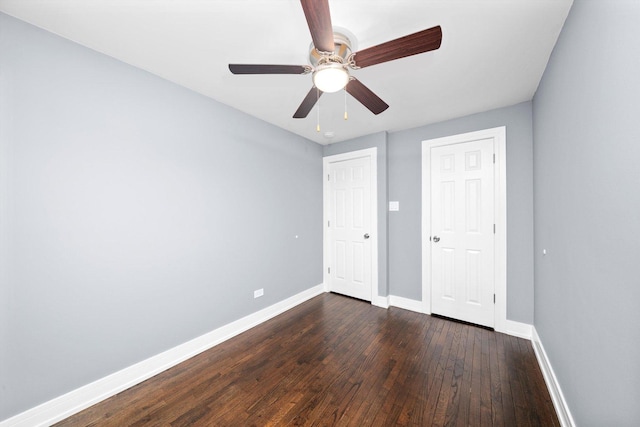 unfurnished bedroom with a ceiling fan, dark wood finished floors, and baseboards