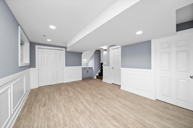 bonus room with recessed lighting, a wainscoted wall, visible vents, stairway, and light wood finished floors