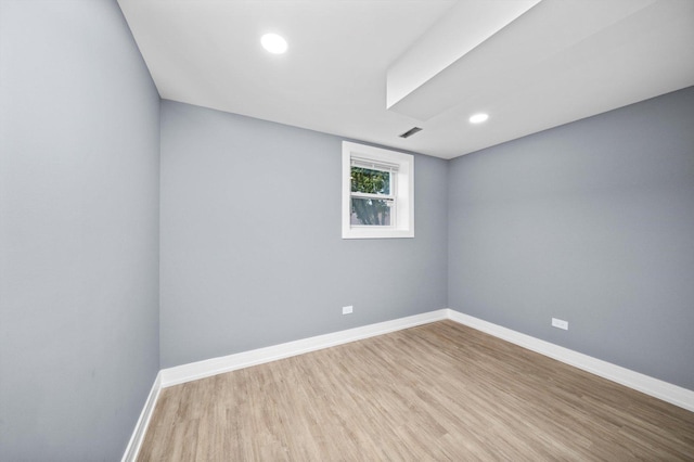 unfurnished room featuring visible vents, baseboards, and wood finished floors