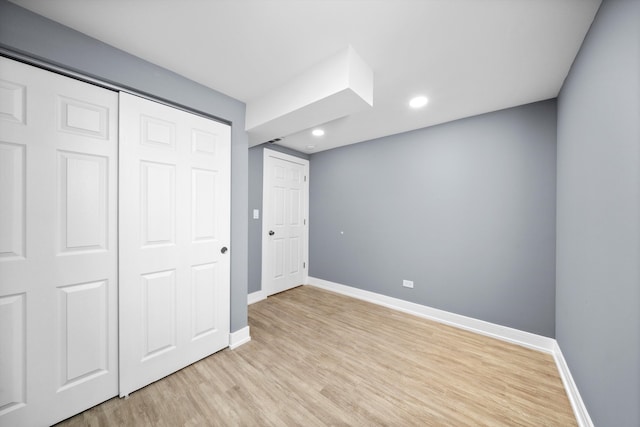 unfurnished bedroom with light wood-type flooring, baseboards, a closet, and recessed lighting