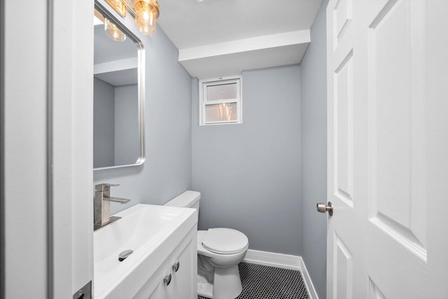 bathroom with baseboards, vanity, and toilet