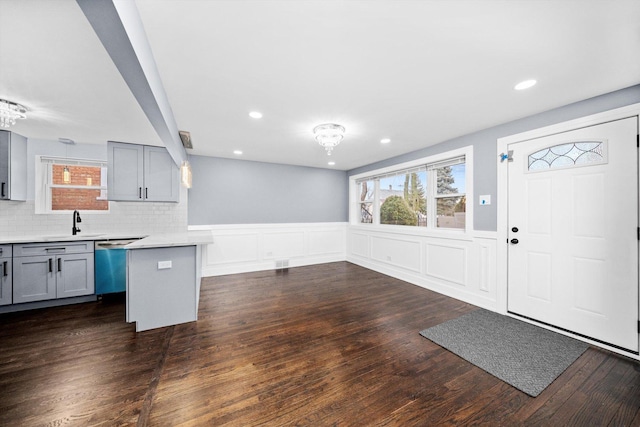 kitchen featuring light countertops, a healthy amount of sunlight, dishwasher, and gray cabinetry