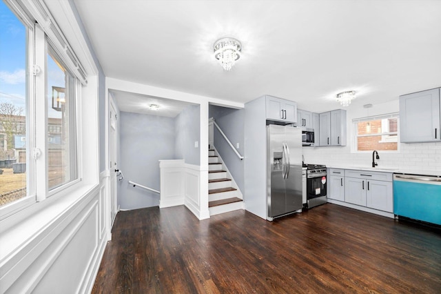 kitchen with dark wood-style flooring, appliances with stainless steel finishes, gray cabinets, and a sink