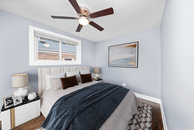 bedroom featuring a ceiling fan, baseboards, and wood finished floors