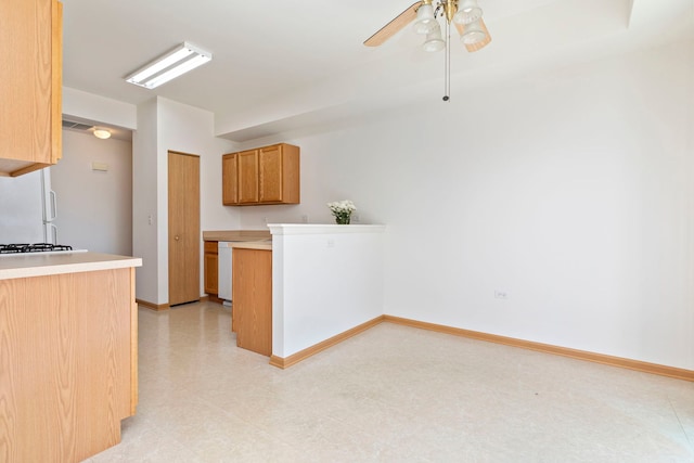 kitchen with light floors, baseboards, light countertops, and a ceiling fan