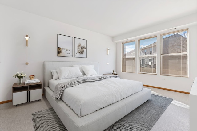 bedroom featuring light carpet and baseboards