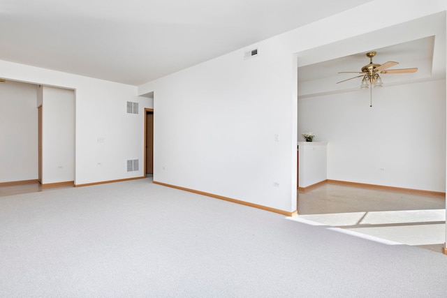 spare room with visible vents, carpet, and a ceiling fan