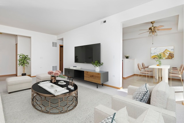 living room with a ceiling fan, visible vents, carpet floors, and baseboards